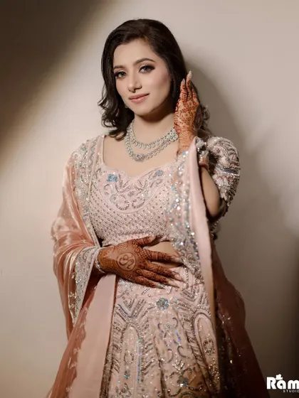 A beautiful close-up portrait of the bride on her engagement day, highlighting her flawless makeup and the delicate embroidery on her outfit.