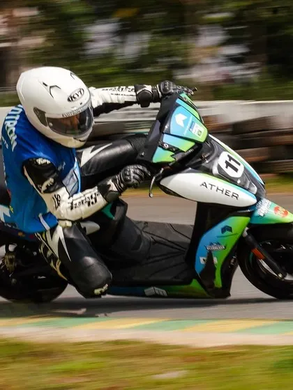 A rider in full racing gear skillfully navigates a corner on an Ather 450X. The event proved that electric scooters can be serious racing machines.