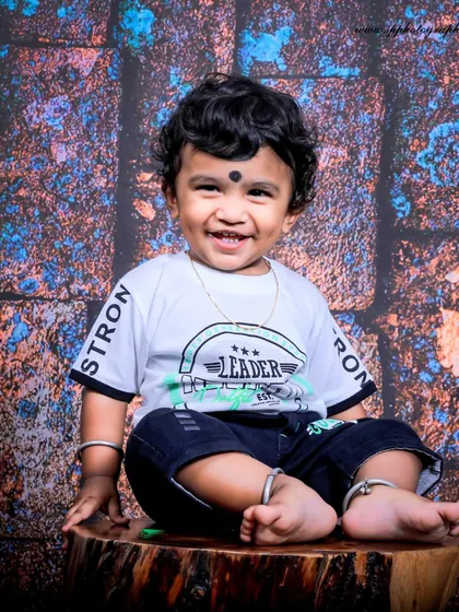A simple, joyful portrait of a smiling toddler. We use a textured backdrop in our studio to add depth while keeping the focus on the child's happy and infectious energy.
