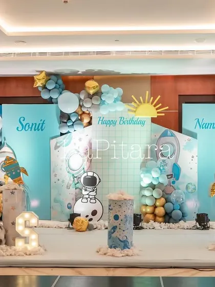 The full stage setup for the indoor portion of the space party, complete with personalized name signs and multiple themed props.