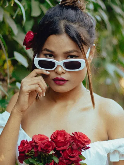 It's all about the swag. A close-up portrait with roses and sunglasses, creating a bold and confident look.