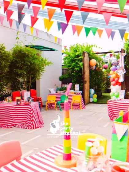 I set up dedicated activity and seating areas for the carnival party, using red-and-white striped tablecloths and colorful chairs to continue the theme. Details like lollipop centerpieces and clown balloon towers added to the fun.