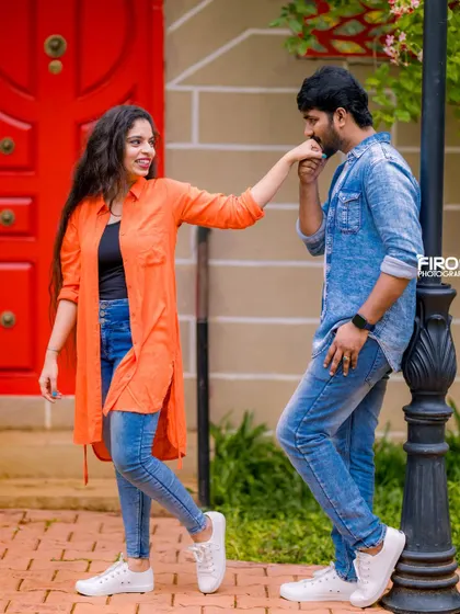 A sweet hand-kiss by a lamppost. This classic romantic gesture looks fresh and modern with the couple's casual denim and tunic outfits.