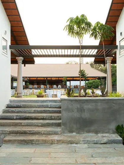 A stone staircase at the Samavana wedding venue leads from a quiet, enclosed passage up towards the open event lawn. This transition from a sheltered space to an open one is a key part of the guest's journey through the site.