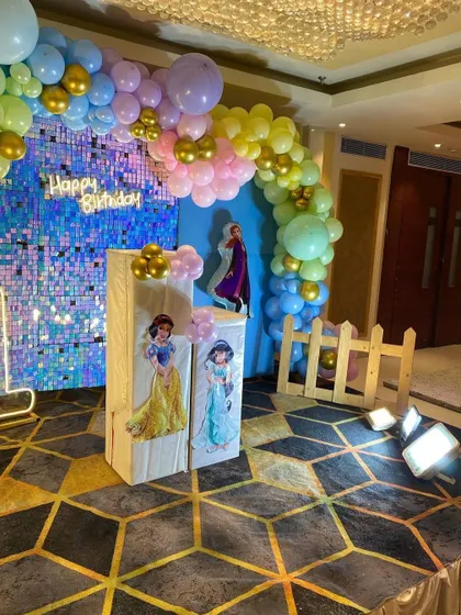 A different perspective of the Disney Princess party decor. This angle shows the light-up marquee number '1' and the placement of the themed pedestals in front of the shimmer wall.