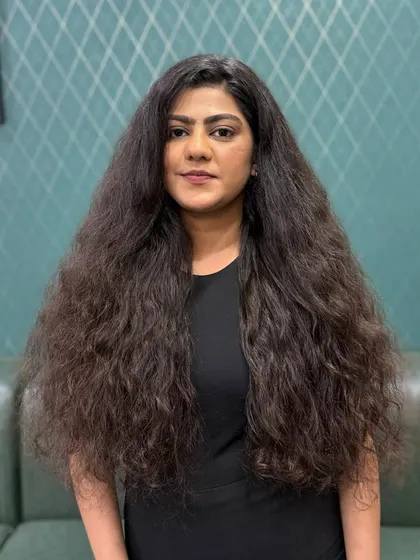 A frontal "before" view, showing the lack of shape and definition in the curls prior to our specialized cut and color service.