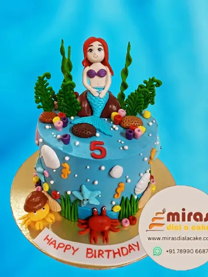 An enchanting underwater scene for a fifth birthday. This Little Mermaid cake features Ariel, Flounder, and Sebastian amidst seaweed and seashells for a magical ocean adventure.