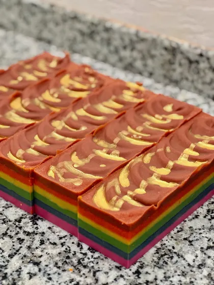 A top-down view of the cut Rainbow soap bars, showcasing the beautiful golden mica swirls on the rich red top layer.
