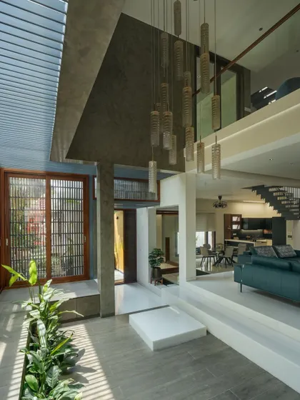 Upon entering, you are greeted by this double-height courtyard. It brings light and nature deep into the heart of the urban home.