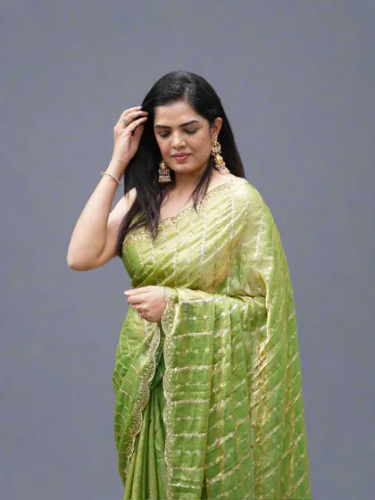 A candid-style shot of the lime green organza tissue saree, highlighting its easy-to-carry and glamorous feel.