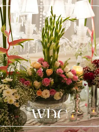 A beautiful floral centerpiece, featuring a mix of roses, lilies, and baby's breath, set against the backdrop of an elegant crystal candelabra.