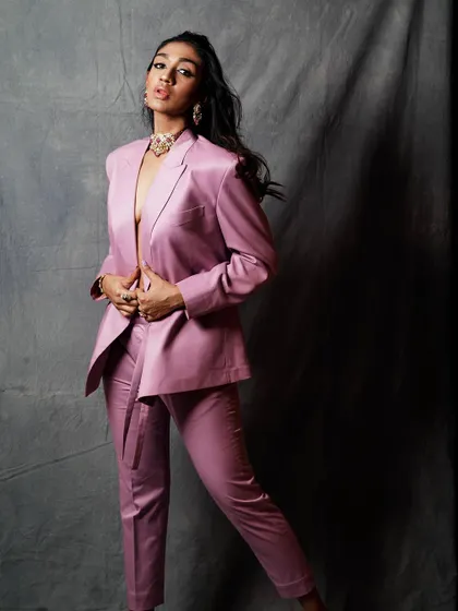 A playful and confident pose in the pink suit. This shot adds a different energy to the series, showing versatility in mood.