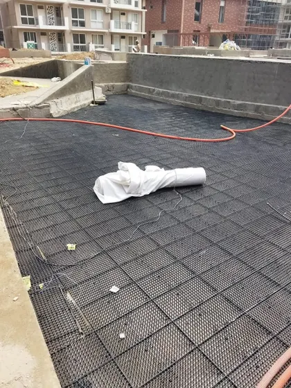 Here you can see the drainage cell system being laid out over a large area. This lightweight and strong material creates a void for water to drain, which is essential for rooftop and podium gardens.
