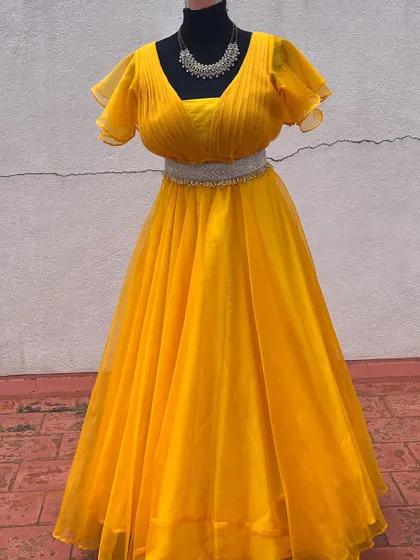 A bright yellow gown with flutter sleeves and an embellished belt.