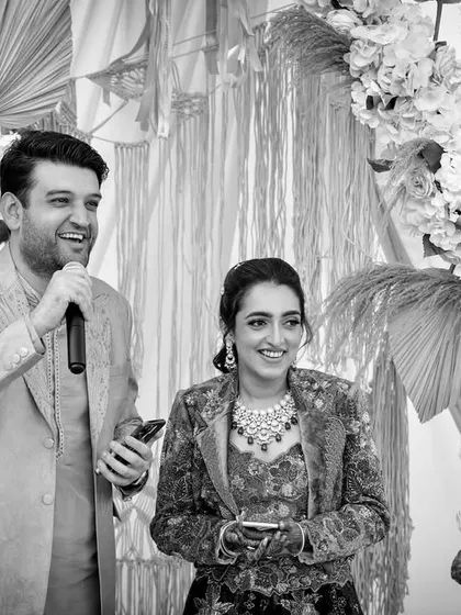 A candid black and white shot of the couple during their beachside Boho-themed welcome lunch, sharing a laugh with their guests.