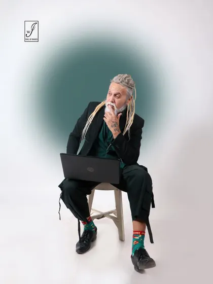 A thoughtful, seated pose that suggests creativity and focus, perfect for a personal branding or lifestyle shoot.