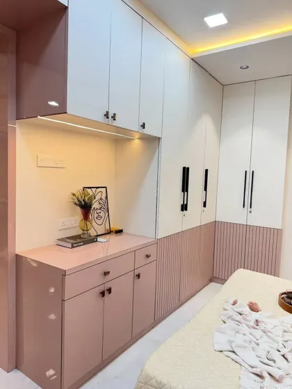 A look at the storage solutions in our pink-themed bedroom. The dual-tone wardrobe in white and pink features both hinged and fluted panel doors, along with a matching chest of drawers, ensuring ample and stylish storage.