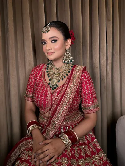 The complete look, showing how our temple jewellery set complements the rich red of her bridal outfit.