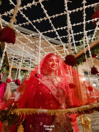 The bride's joyful smile as she is carried in under the phoolon ki chadar. A beautiful candid moment of her wedding entrance.