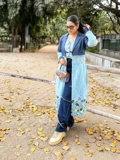 The combination of different denim washes, floral embroidery, and rugged sneakers makes this a perfect example of practical and stylish Indo-western street style.