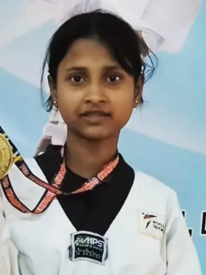 A young student proudly shows off her gold medal from the 7th Warriors Taekwondo Championship.