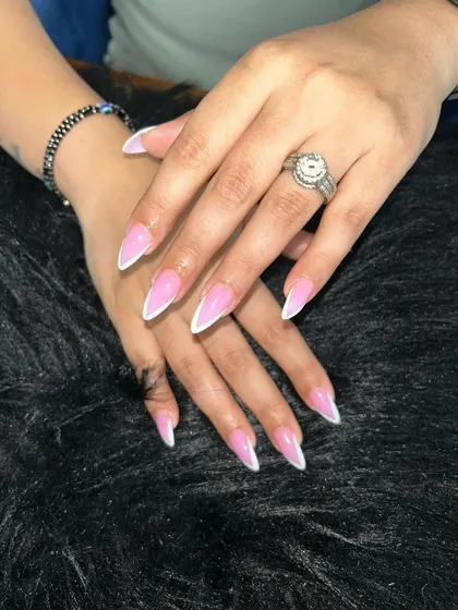 A sharp, stiletto-shaped French manicure. The dramatic length and classic white tip create a bold yet elegant statement.