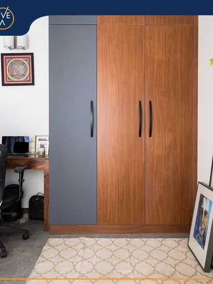 This cozy nook features a dual-tone wardrobe in grey and wood, alongside a compact work desk. It's a perfect example of how we maximize functionality in a small space without sacrificing style.