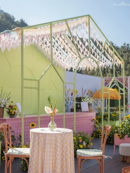 A pastel green and pink bar area, with a roof of delicate bunting, adds to the playful and colorful atmosphere.