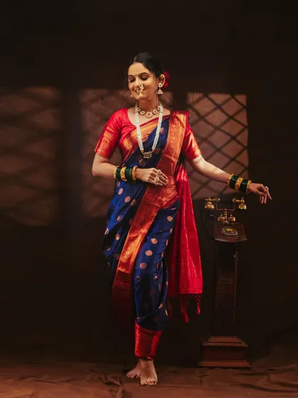 A dynamic pose that shows the flow and movement of the saree. The vintage telephone prop adds a nice touch.