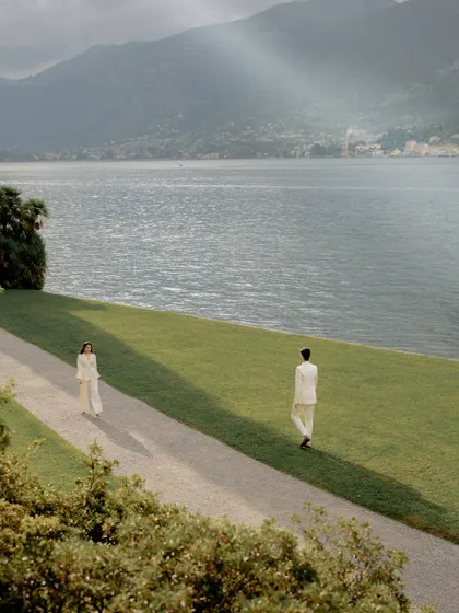 A breathtaking view of Lake Como, with the couple walking along a path, dwarfed by the majestic landscape. This shot highlights our ability to capture both intimacy and scale.