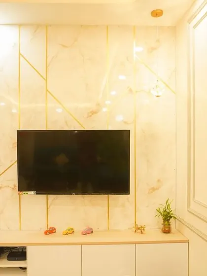 A living room with a TV unit featuring a marble back panel with gold T-patty inlay and louvered wood accents. The design is a perfect blend of luxury and warmth.