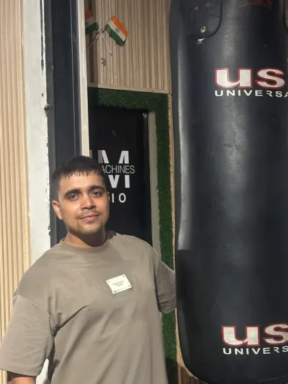 Standing next to the punching bag.