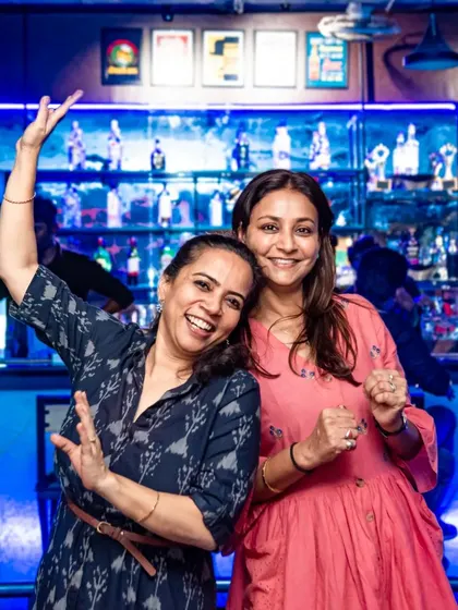 Two friends having a fantastic time, dancing and posing for the camera.