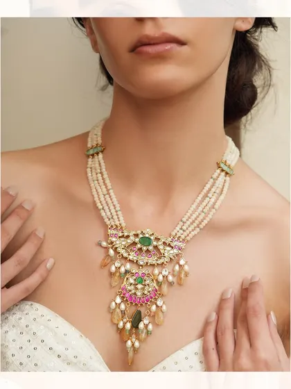 A beautiful layered pearl necklace with a central pendant featuring pink and green stones.