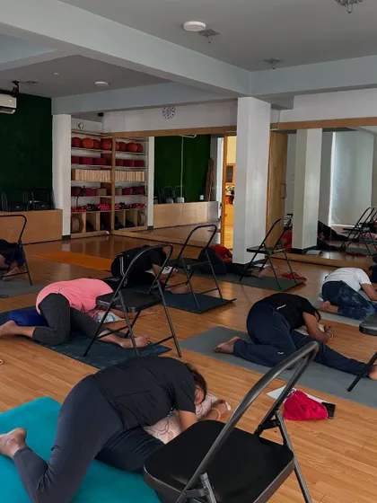 A group of students in a supported forward bend during the PCOD/PCOS workshop. These poses help calm the nervous system.