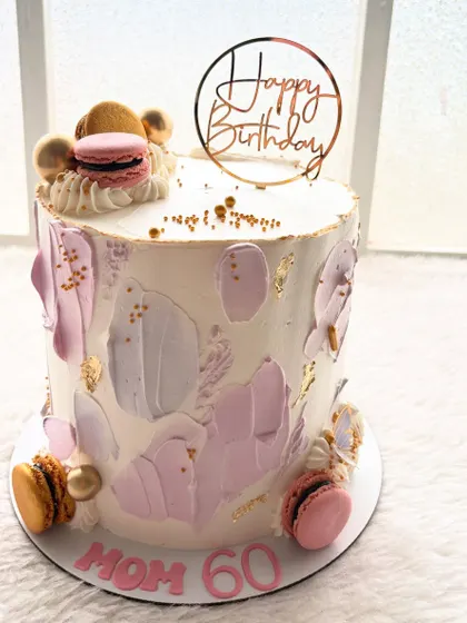 Celebrating a 60th birthday in style with this textured palette knife cake. The shades of lilac and gold, topped with macarons, create a sophisticated and artistic look.