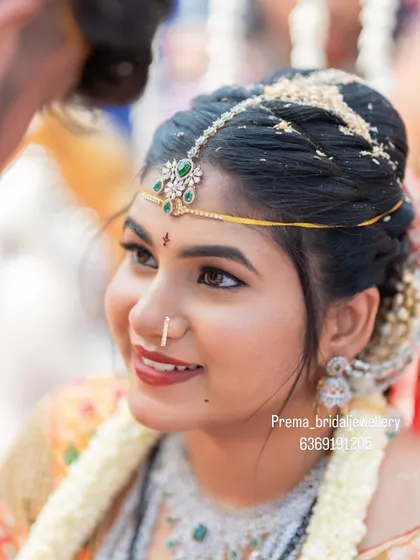 A close-up on the beautiful maang tikka with green stone detailing.