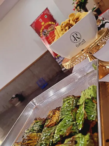 Another look at my banana leaf-wrapped paneer starters, alongside a bowl of crispy snacks. I focus on providing a diverse menu of appetizers to suit any taste.