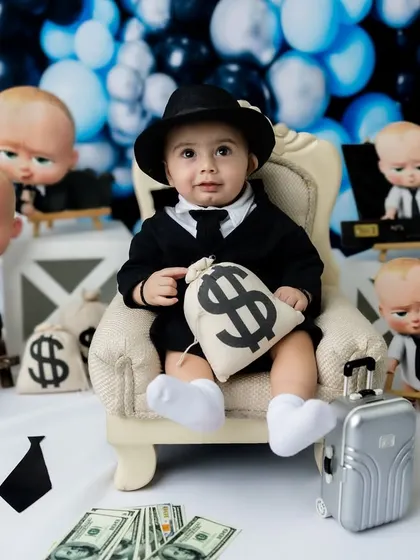 This little boss is in charge. The full setup with the backdrop, props, and costume creates a complete story.