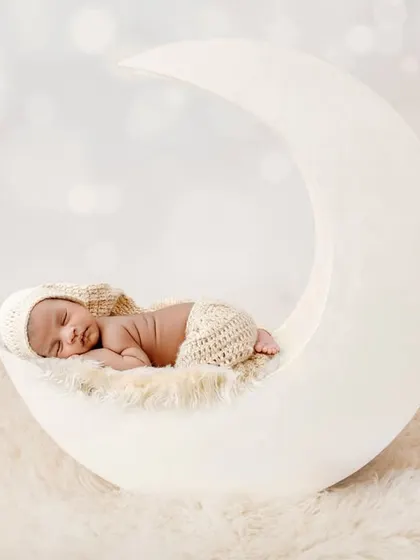A journey to the stars on my custom moon prop. This dreamy, all-white setup is a client favorite, creating serene and angelic portraits that feel timeless. The soft textures and lighting are designed to highlight your baby's delicate features.
