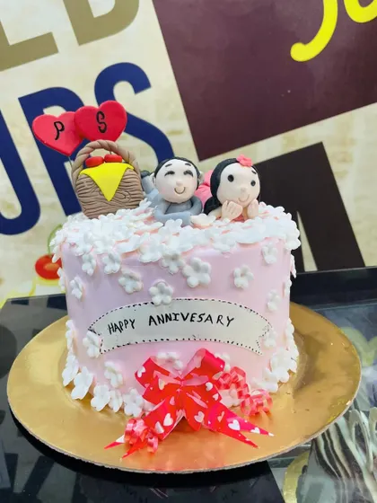 A charming 2kg anniversary cake with fondant couple toppers and delicate white flowers.