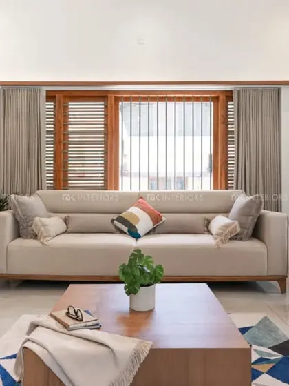 A simple and elegant living room with light-colored fabric sofas and wooden legs. The space feels calm and uncluttered, with a large piece of art adding a personal touch.