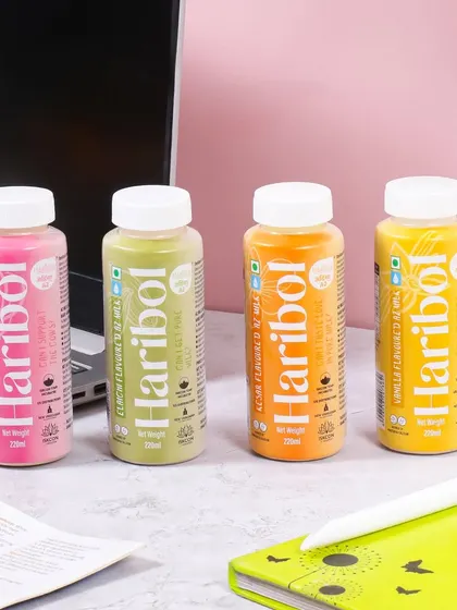 A lifestyle shot showing a range of flavored milk drinks in a modern workspace setting. This places the product in the context of a busy professional's life, positioning it as a convenient and healthy on the go option.