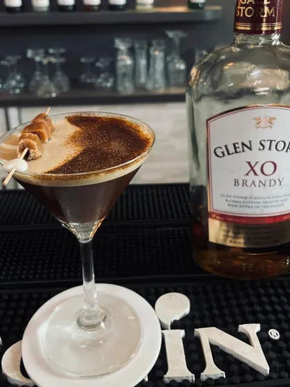 A creative take on the Brandy Alexander, served in a martini glass with a marshmallow and caramel skewer.