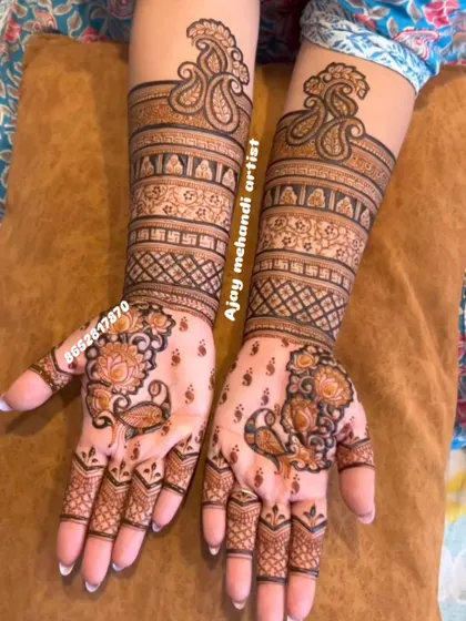 This design showcases a beautiful mix of paisley and floral motifs. The patterns extend up the forearm in symmetrical bands, creating an elegant and traditional bridal look.