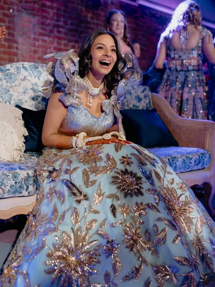 A full-length view of the bride's spectacular Sangeet outfit. The makeup is glamorous and designed to sparkle on the dance floor.