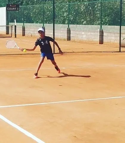 A junior player makes contact with the ball on a forehand shot during the Tennis360 Academy UTR tour.