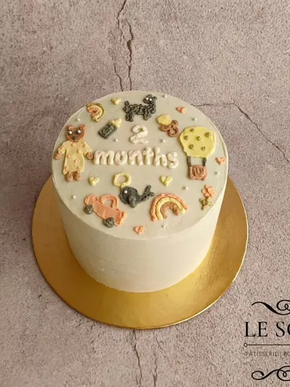 A cake to celebrate the two-month milestone. This one-pound Chocolate Caramel cake is decorated with tiny, hand-piped buttercream details like a teddy bear, a car, a rainbow, and a milk bottle.