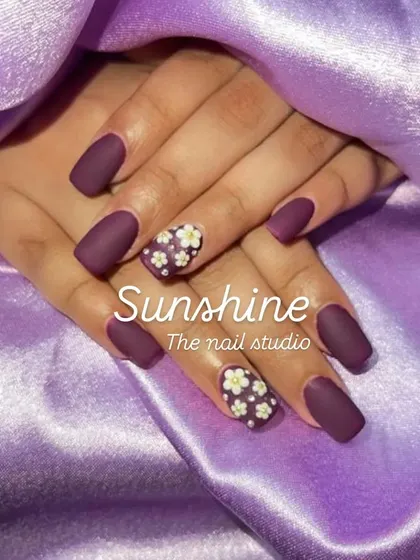 A matte purple set with hand-painted white and yellow flowers on the accent nails.