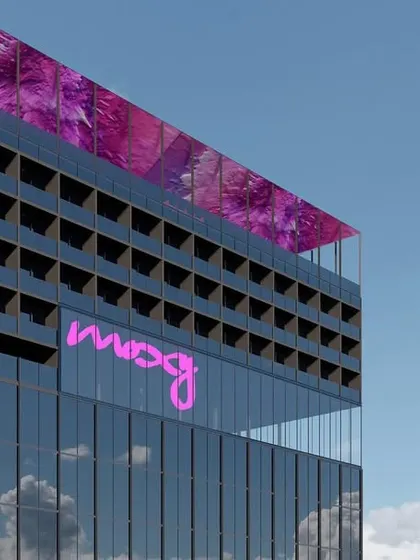 A close up of the SLN Tower design. The vibrant pink branding and the dynamic, pixelated graphic on the rooftop canopy were envisioned to make the building a vibrant urban hub with a strong, contemporary identity.